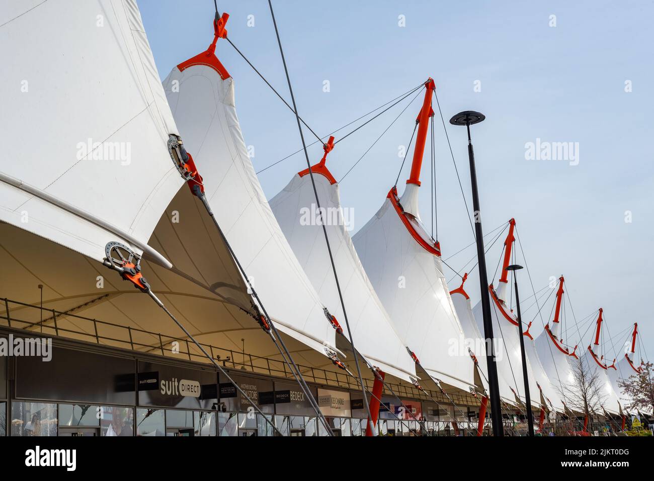 Close up view of the distinctive white roof canopy and shops underneath at Ashford Outlet Center, Kent, England.  Stock Photo