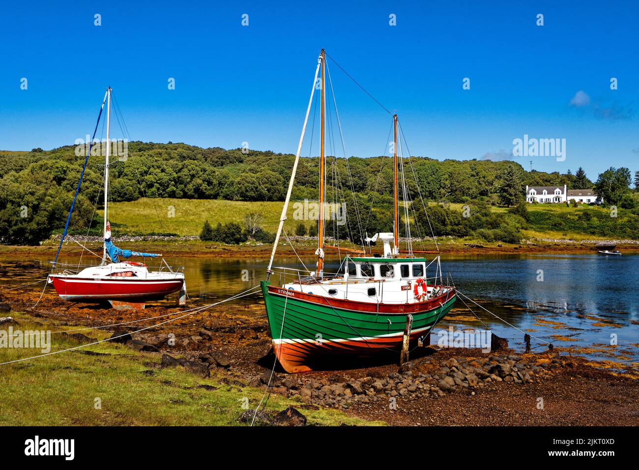 BADACHRO ROSS AND CROMARTY SCOTLAND THE BAY WITH MOORED BOATS AND BRIGHT ORANGE SEAWEED IN SUMMER Stock Photo