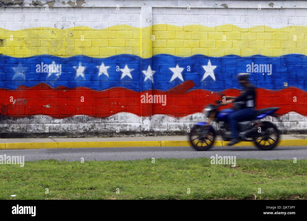 August 3, 2022: August 03, 2022. A motorcycle travels in front of a graffiti with the Venezuelan flag. Venezuela celebrates the day of the national flag. Since on August 3, but in 1806, 212 years ago, Generalissimo Francisco de Miranda, in the ship called Leander, touched Venezuelan land in the Vela de Coro and waved for the first time in the country the tricolor flag. Photo: Juan Carlos Hernandez (Credit Image: © Juan Carlos Hernandez/ZUMA Press Wire) Stock Photo