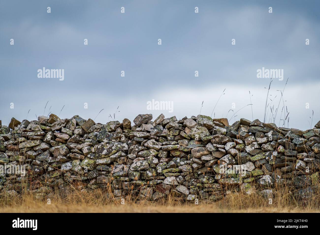 Ancient stone wall under cloudy stormy sky Stock Photo