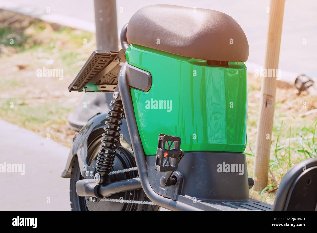 Electric scooter or eco-friendly bike with battery parked in the city park. Modern transportation concept Stock Photo