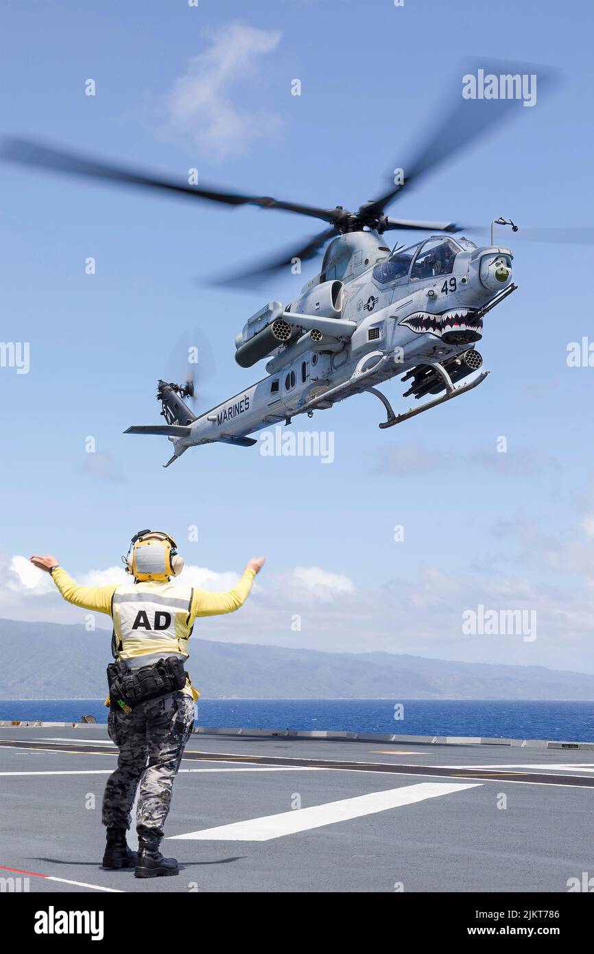 Pacific Ocean, United States. 01 August, 2022. A U.S. Marine Corps AH-1Z Viper attack helicopter is signaled to land on the flight deck of Royal Australian Navy Canberra-class landing helicopter dock ship HMAS Canberra during an amphibious assault at the Rim of the Pacific exercise, July 28, 2022 off the coast of Hawaii, USA.  Credit: Seaman Matthew Lyall/US Navy/Alamy Live News Stock Photo