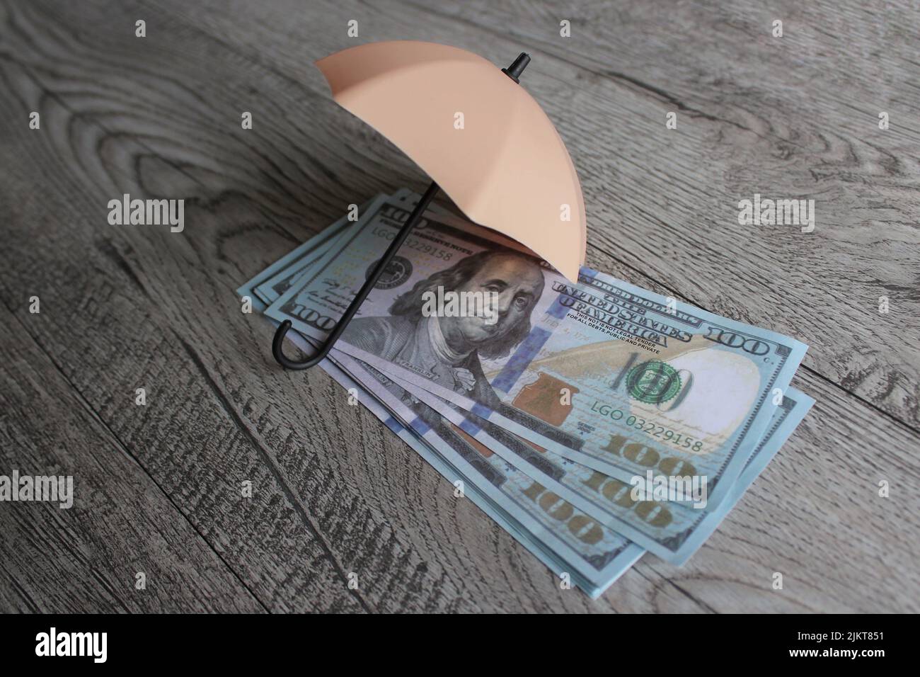 Stack of money and umbrella for protection with copy space. Financial safety and investment concept. Stock Photo