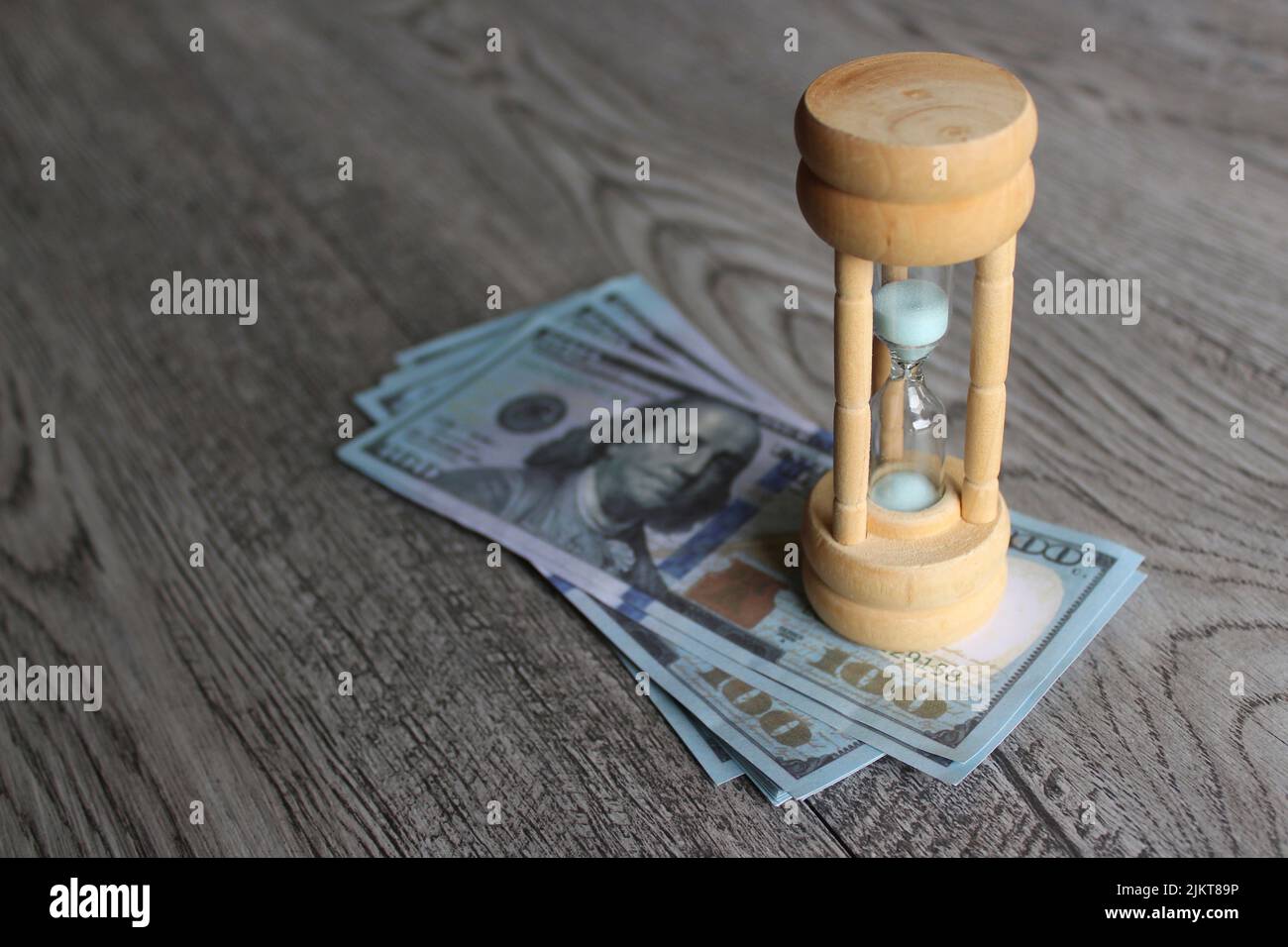 Growth of income over time and return on investment concept. Hourglass and stack of money on table Stock Photo