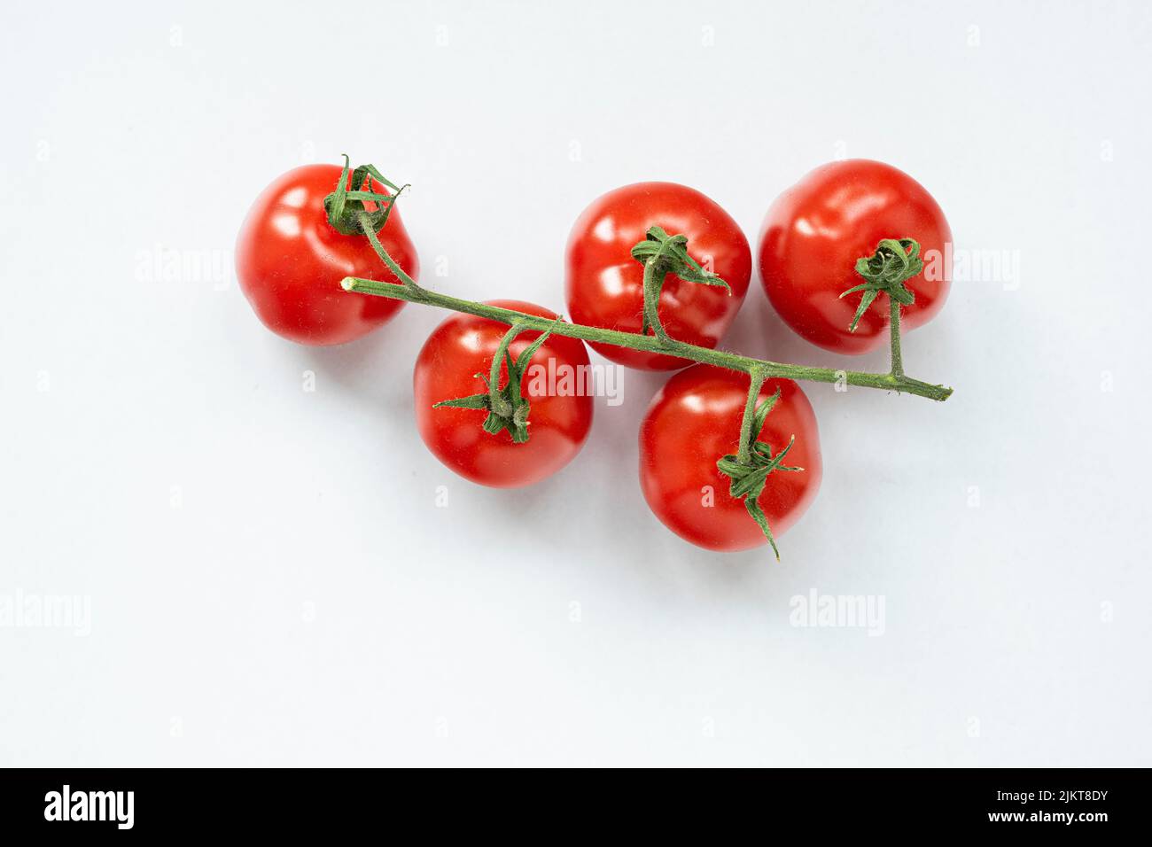 A closeup of a bunch of cherry tomatoes isolated on white background ...