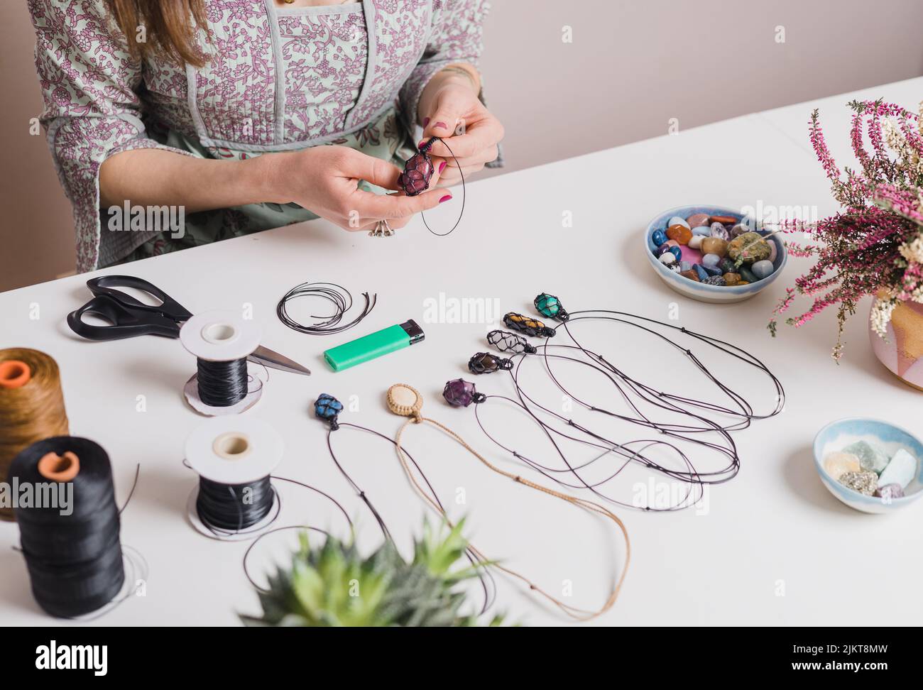 Woman hands making handmade gemstone jewellery, home workshop. Women artisan creates jewellery. Art, hobby, handcraft concept Stock Photo