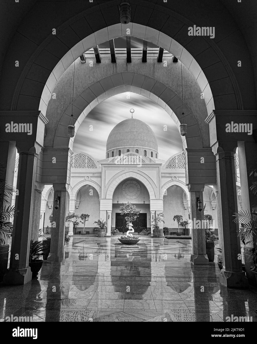 A vertical grayscale view of a mausoleum with luxuriant decorations with a pointed arch Stock Photo