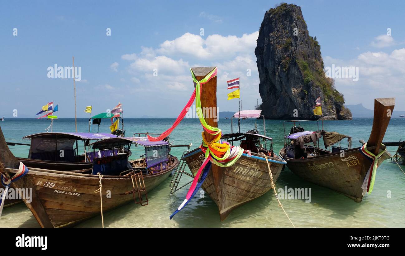 Traditional long tail boats in front of the big rock of Koh Poda Island in Thailand Stock Photo