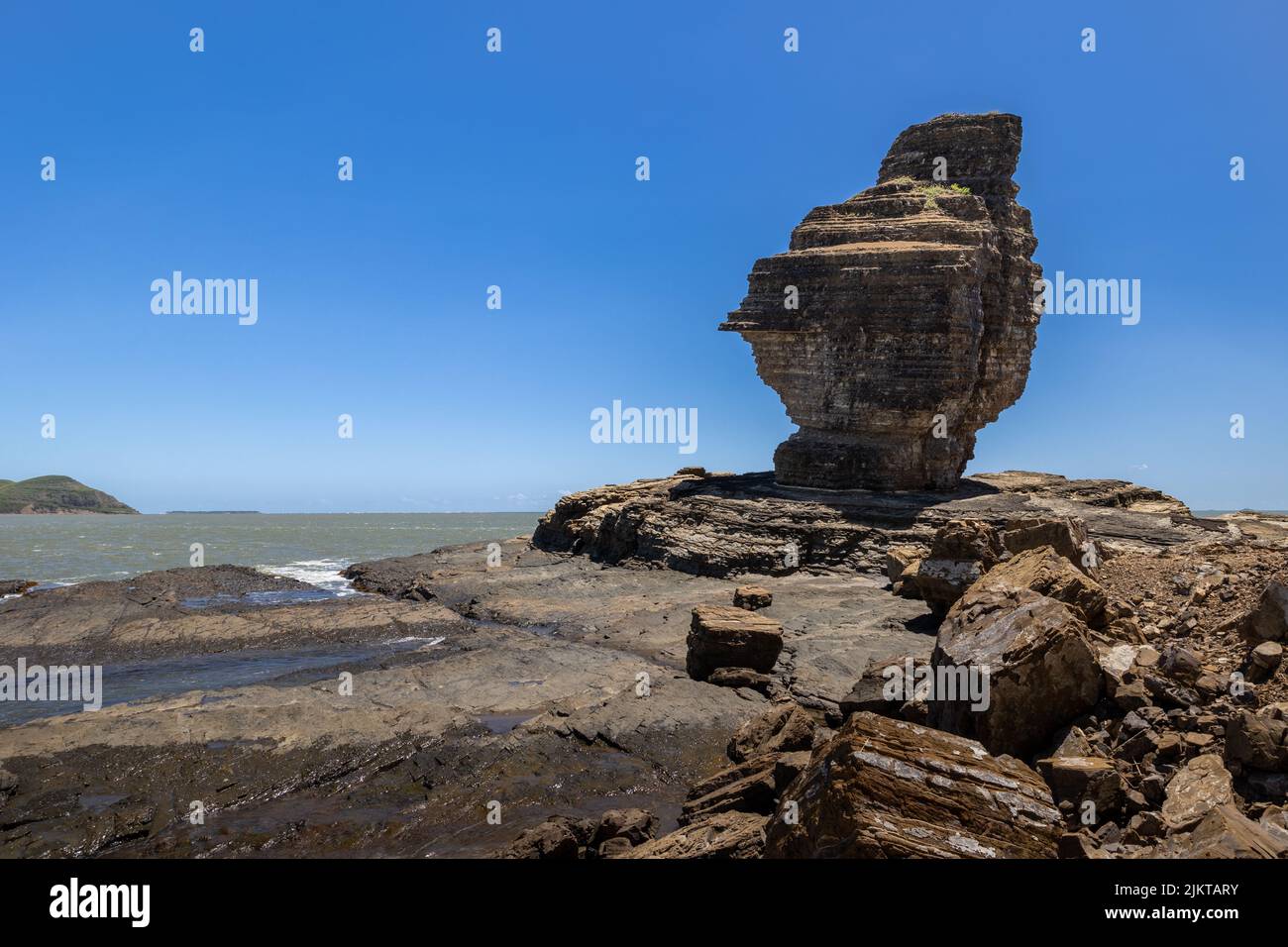 Man from Bourail at pierced rock beach (plage de la roche percee) Beautiful rock at sea Stock Photo