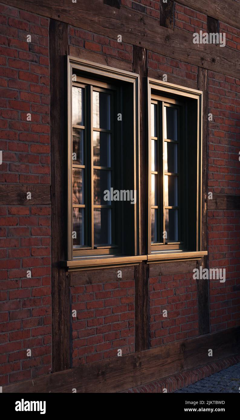 the view of an old window located in old brick wall drowned in morning sunlight Stock Photo