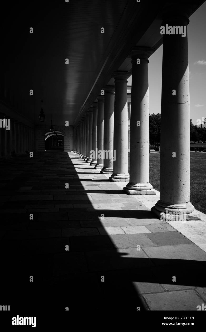 A grayscale of an old building corridor with columns Stock Photo