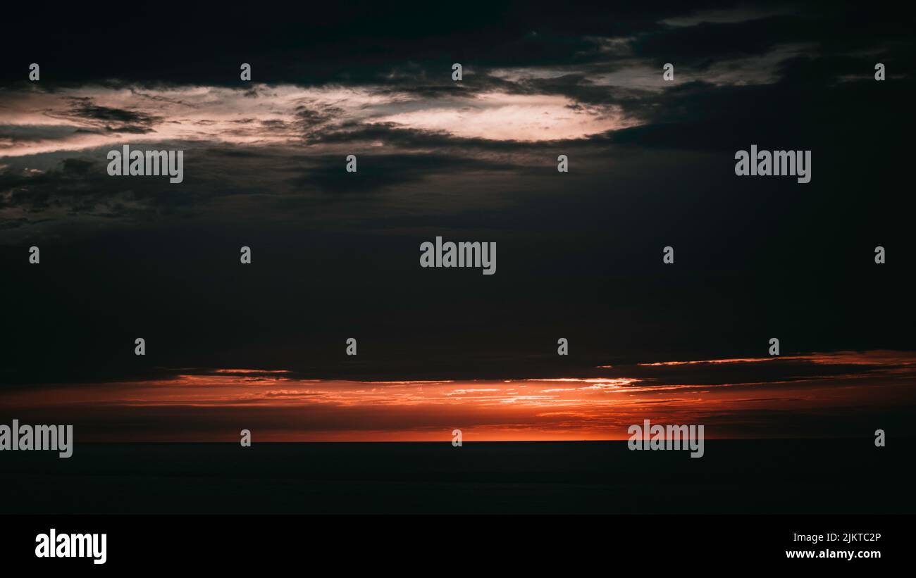 A beautiful view of an orange sunset over the sea Stock Photo - Alamy