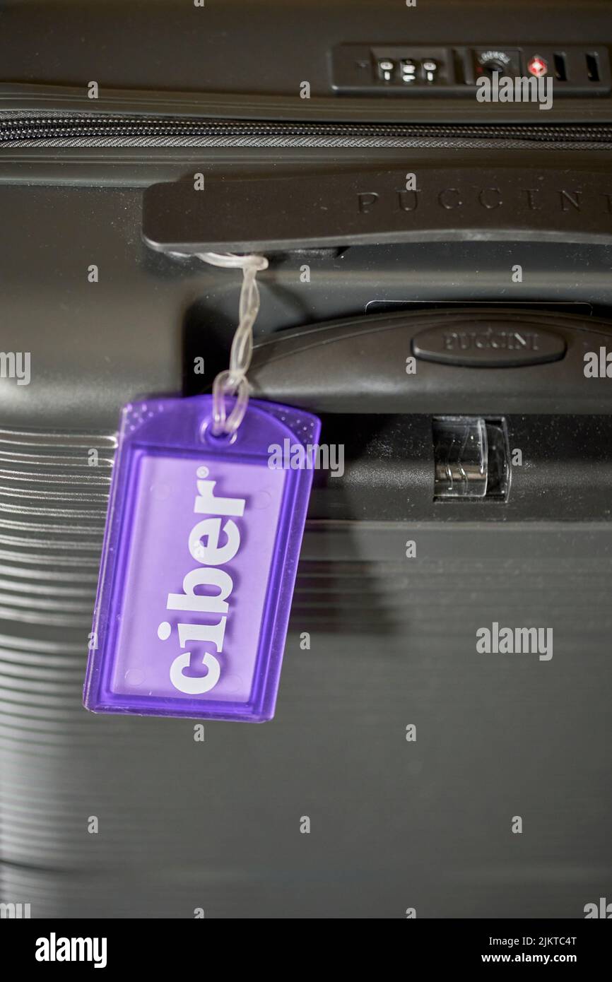 A vertical closeup of a travel suitcase with a Ciber company tag. Stock Photo