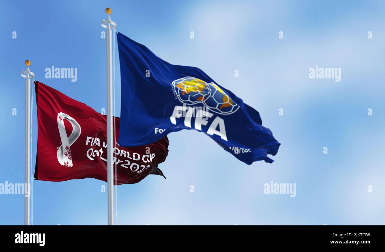Doha, Qatar, January 2022: Flags with FIFA and Qatar 2022 World Cup logo waving in the wind. The event is scheduled in Qatar from 21 November to 18 De Stock Photo