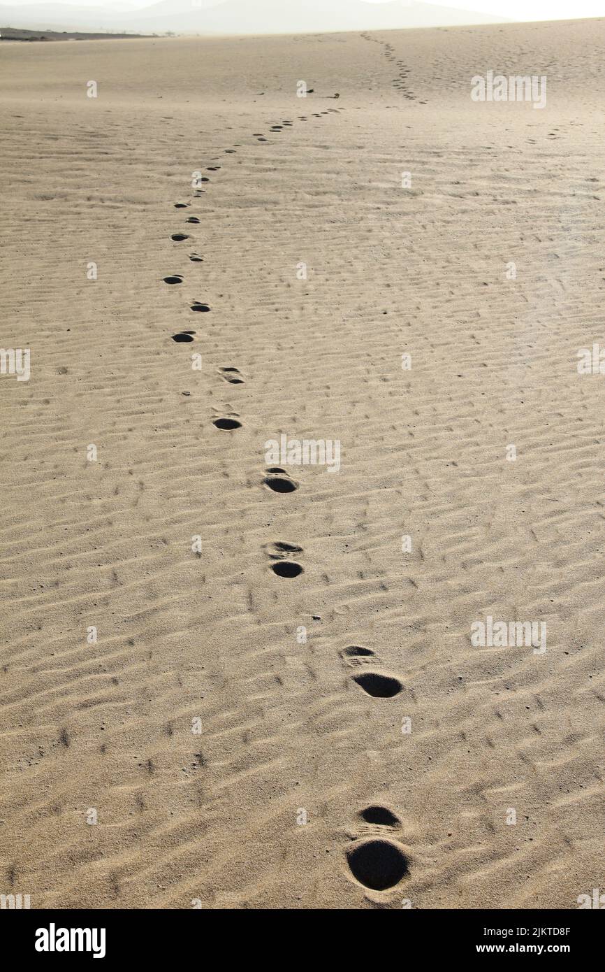 Line of footprints in a spacious desert landscape on Fuerteventura, Spain Stock Photo
