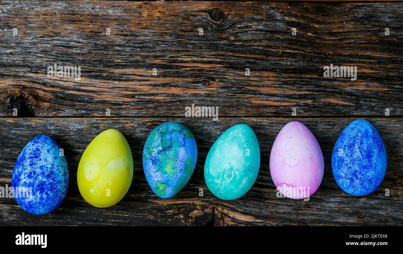 Painted and colored Easter eggs on rustic wooden table Stock Photo