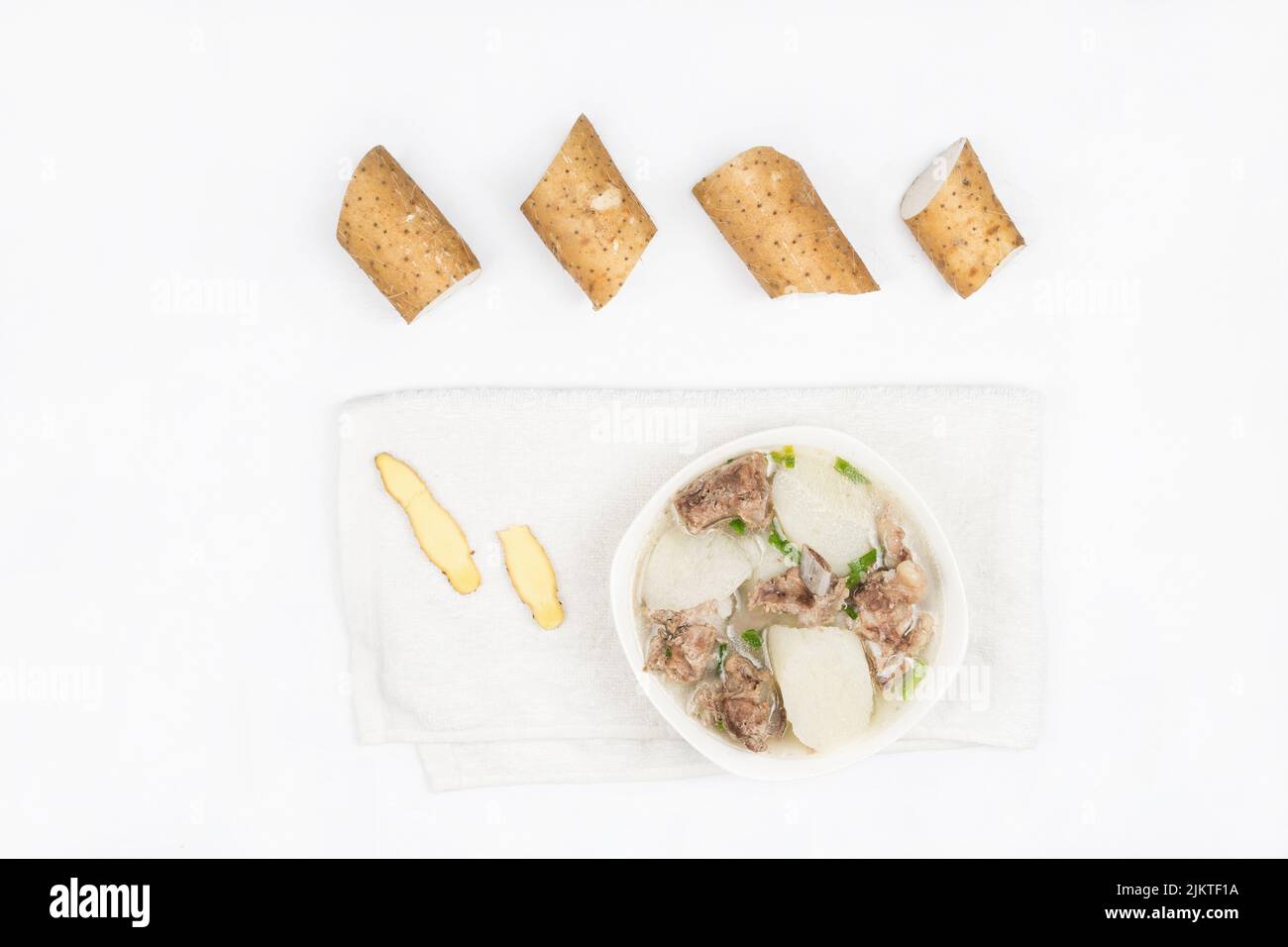A closeup top view of Stewed Pork Ribs with Chinese Yam on a white
