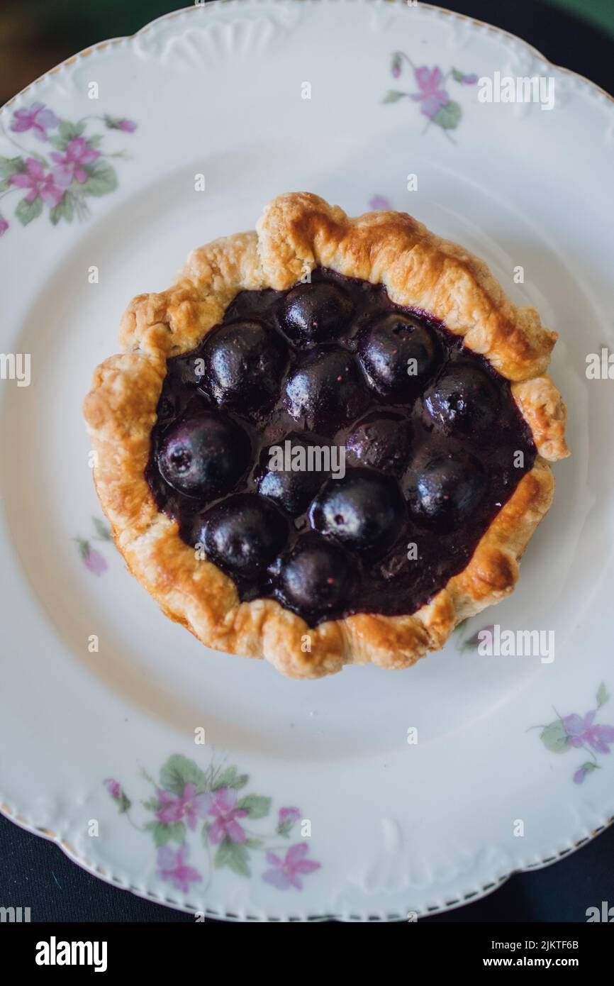 mini blueberry tart dessert on white and purple floral porcelain plate Stock Photo