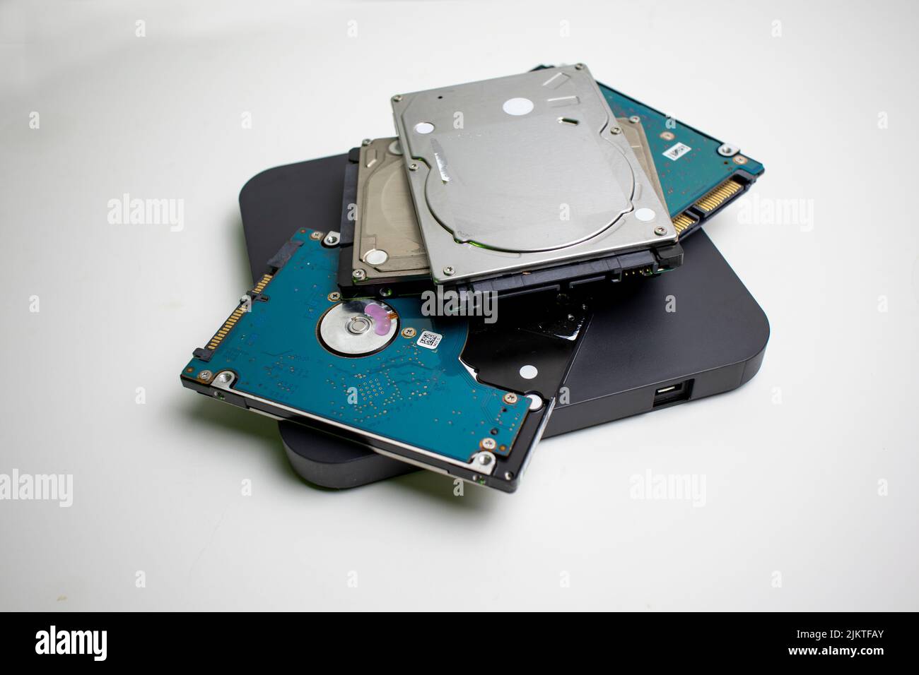 Stack of internal laptop hard drives in a pile on a white background