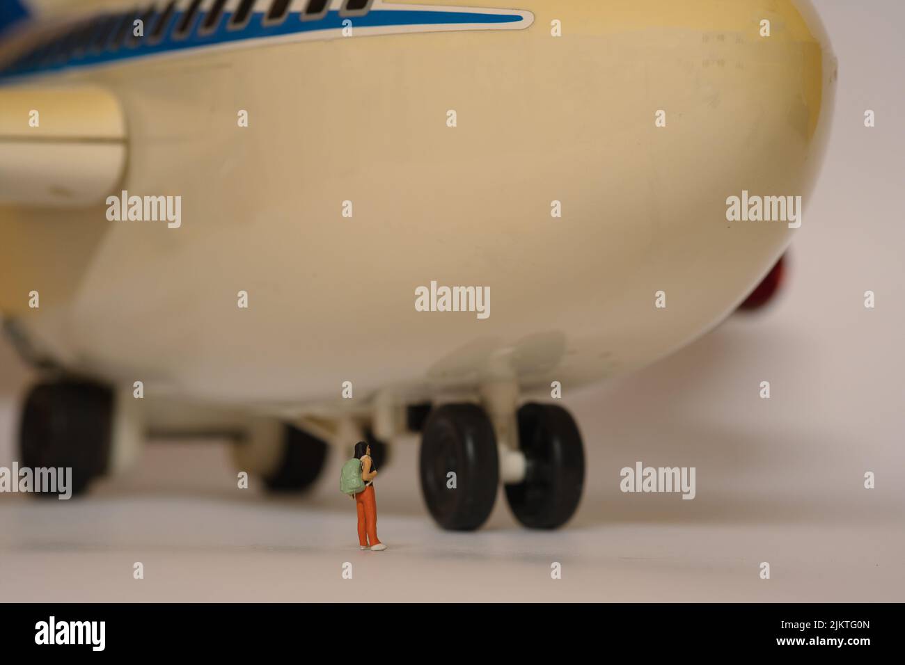 a huge airplane , front view where a traveler with a backpack stands in front of the wheels Stock Photo