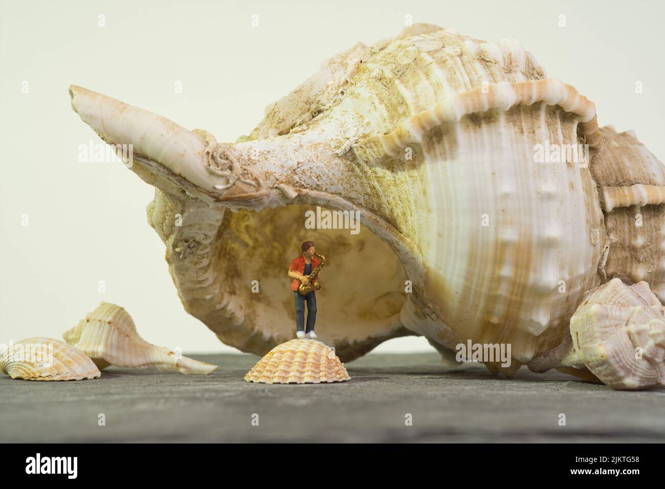 Saxophonist plays under a giant sea snail shell Stock Photo