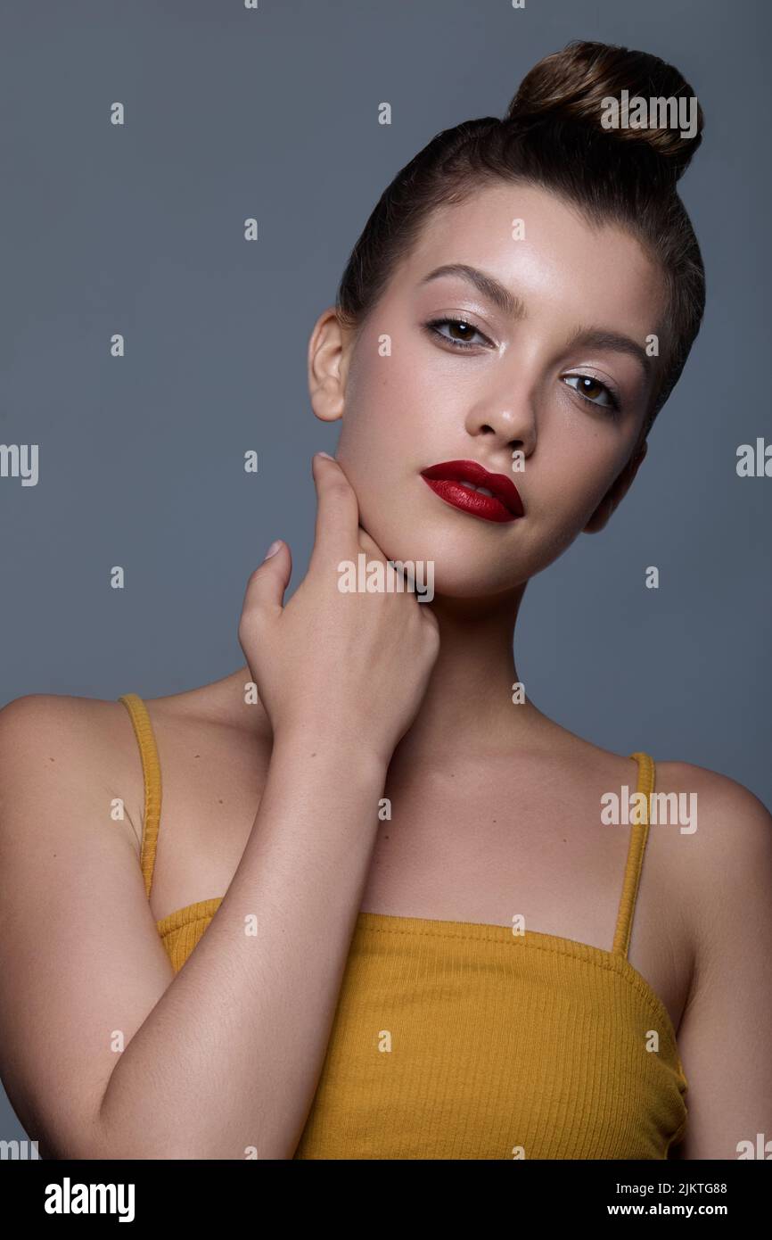 A portrait of a Caucasian female with hair in a bun and red lips Stock Photo