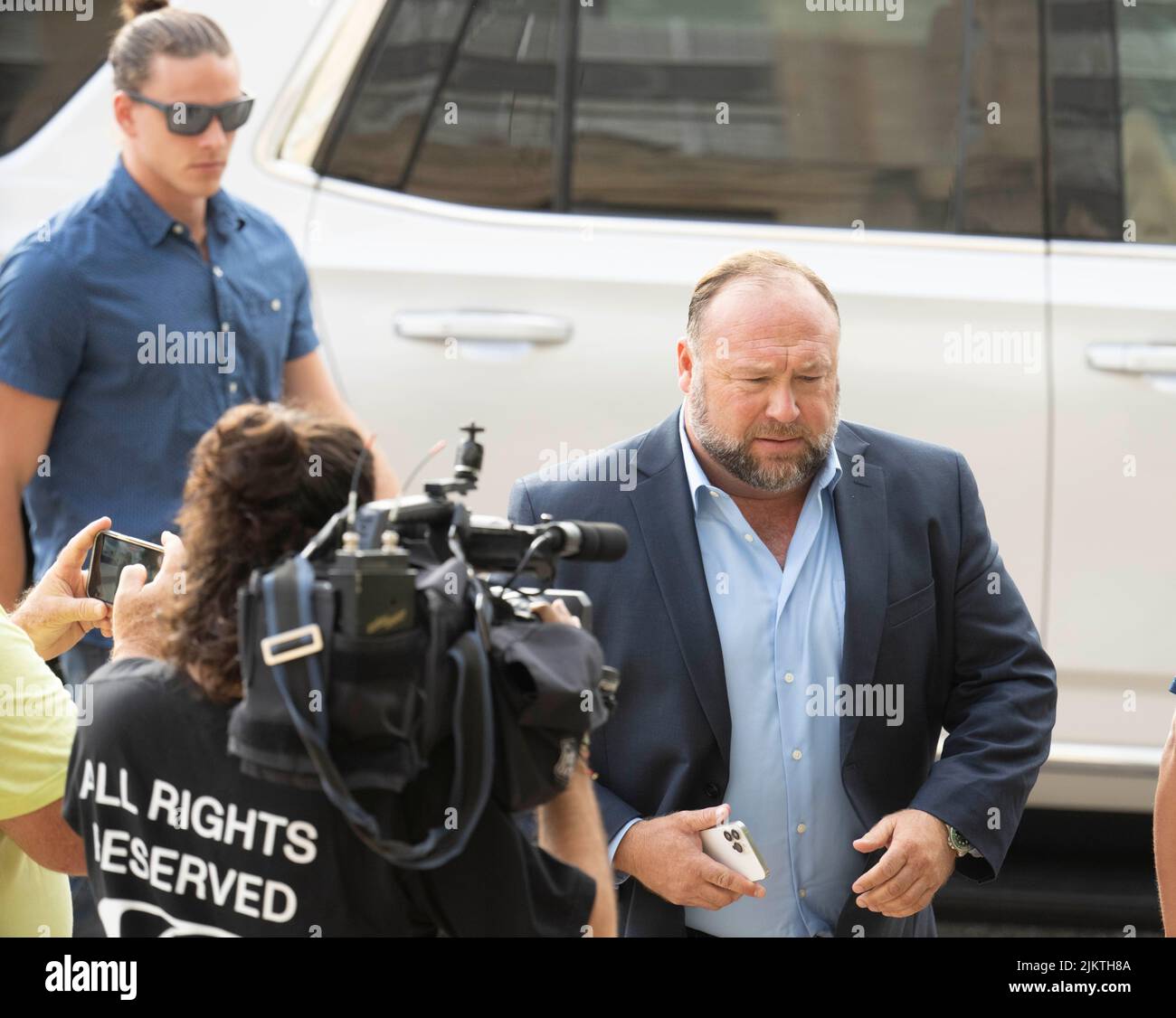 Flanked by a security team, ALEX JONES arrives in the morning at the Travis County Courthouse in Austin for day 7 of the his defamation trial with Sandy Hook survivors on August 3, 2022. Jones took the stand for a second time and the trial is expected to end this week. Credit: Bob Daemmrich/Alamy Live News Stock Photo