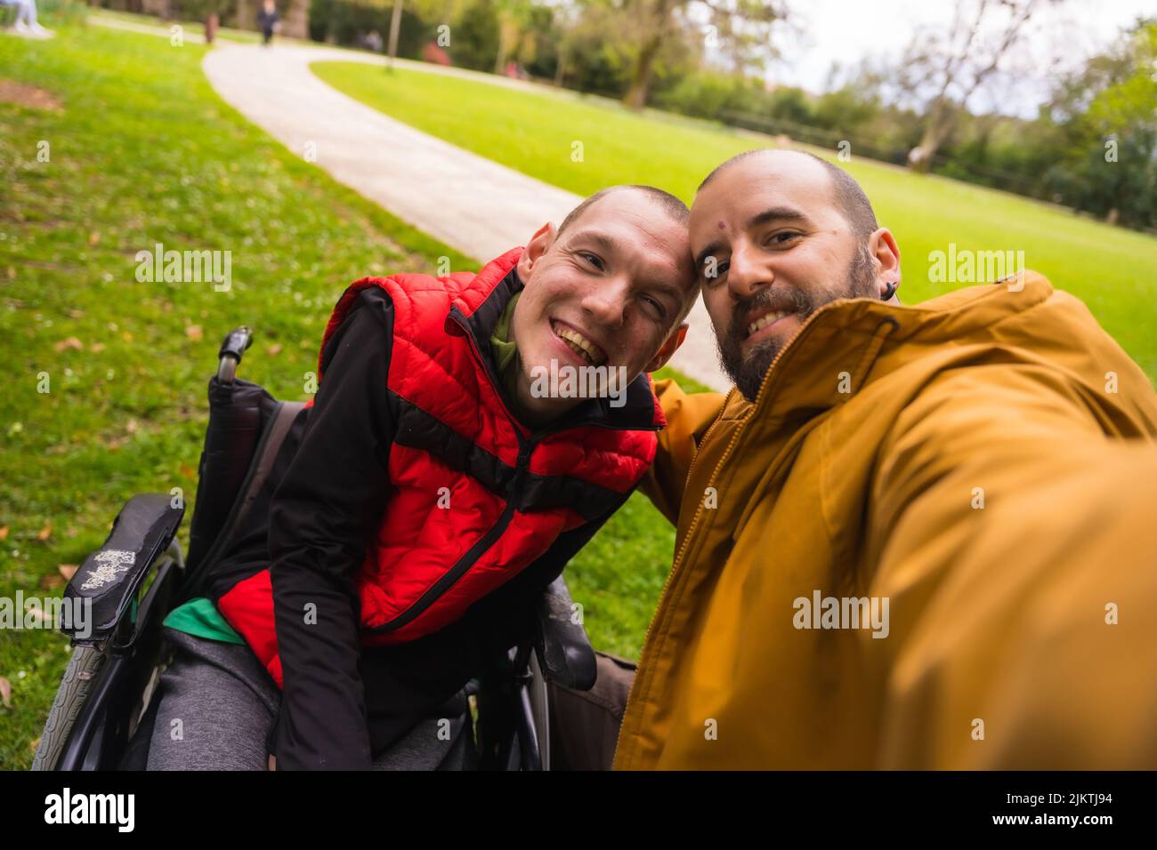 Selfie of a paralyzed young man in a wheelchair with a friend on a ...