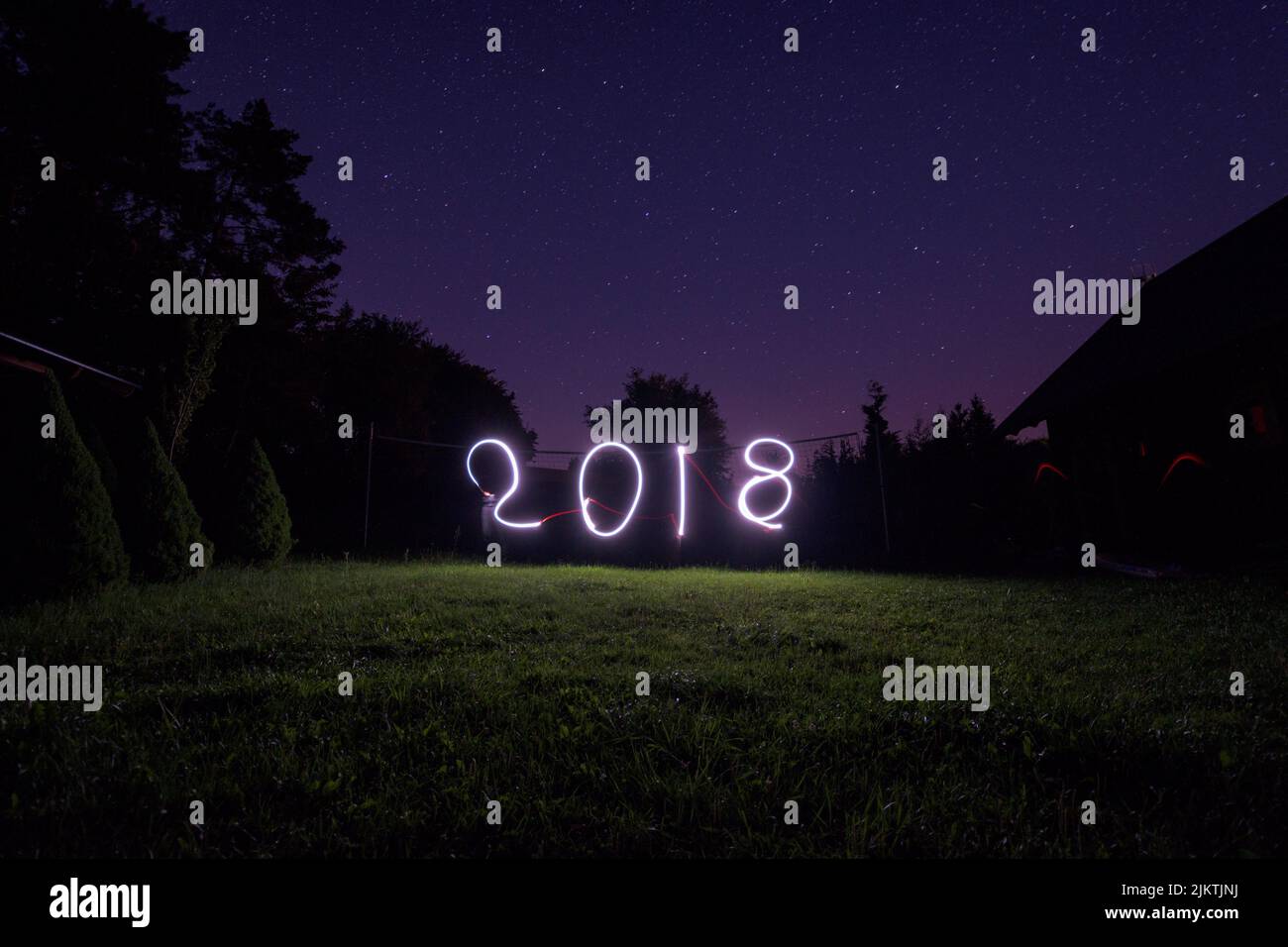 A view of the number '2018' written in neon lights in the backyard of a private house Stock Photo