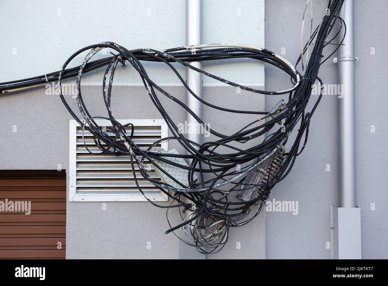 Tangled messy electrical cables on building wall Stock Photo Alamy