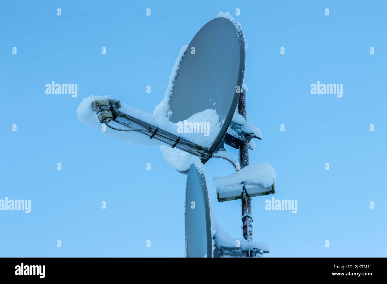 Snow-covered satellite dish prevents the reception signal to the TV Stock Photo