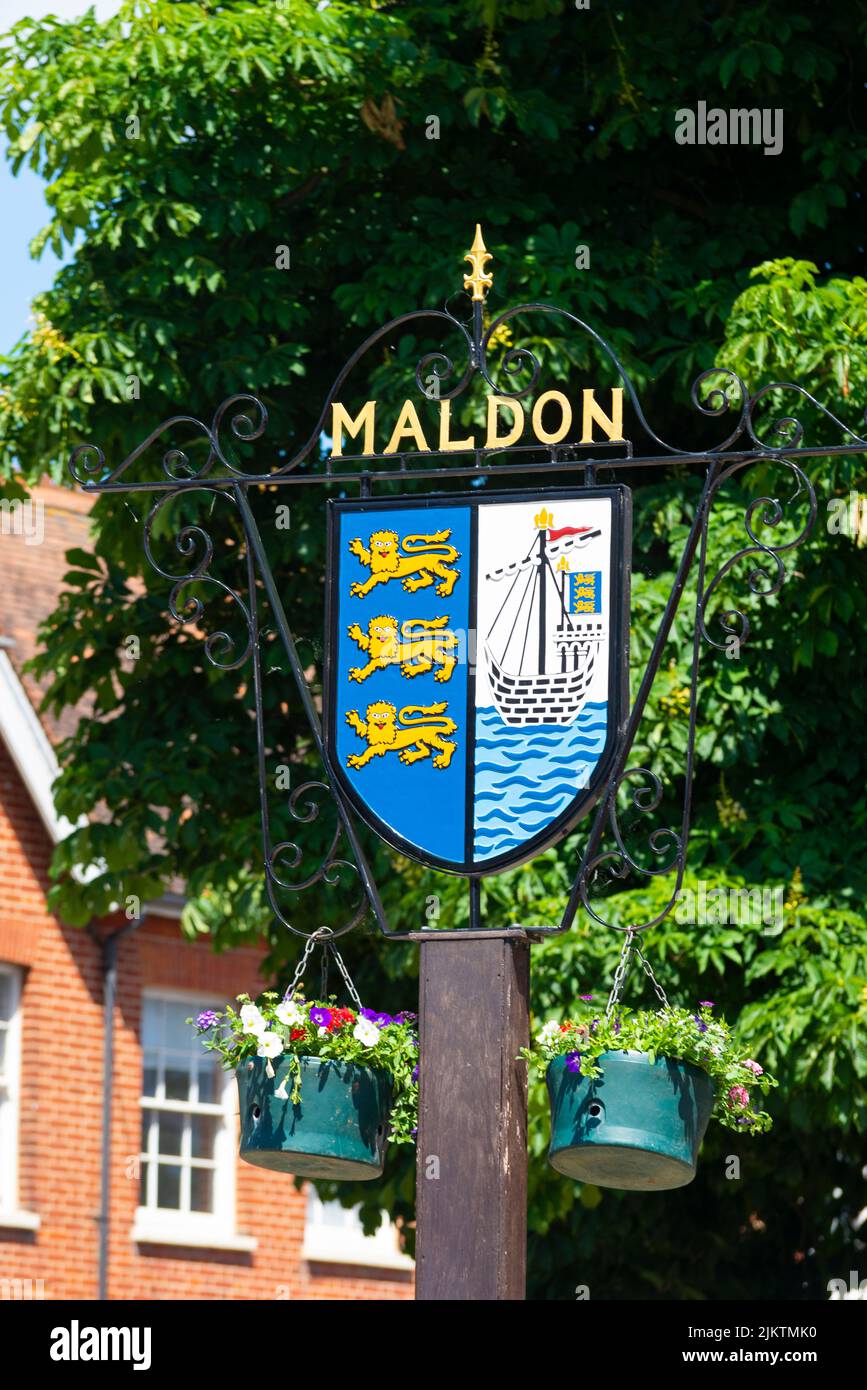 Maldon town sign, with town coat of arms featuring lions and an east coast sailing barge on the River Blackwater. Hanging baskets Stock Photo