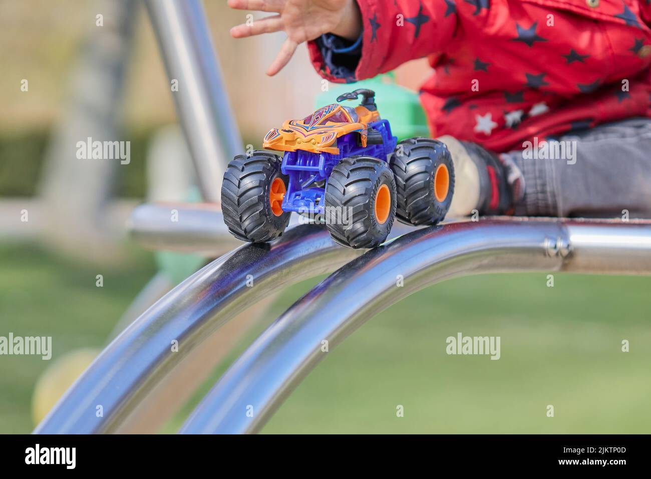 A child playing with a hot wheels monster truck in the playground Stock