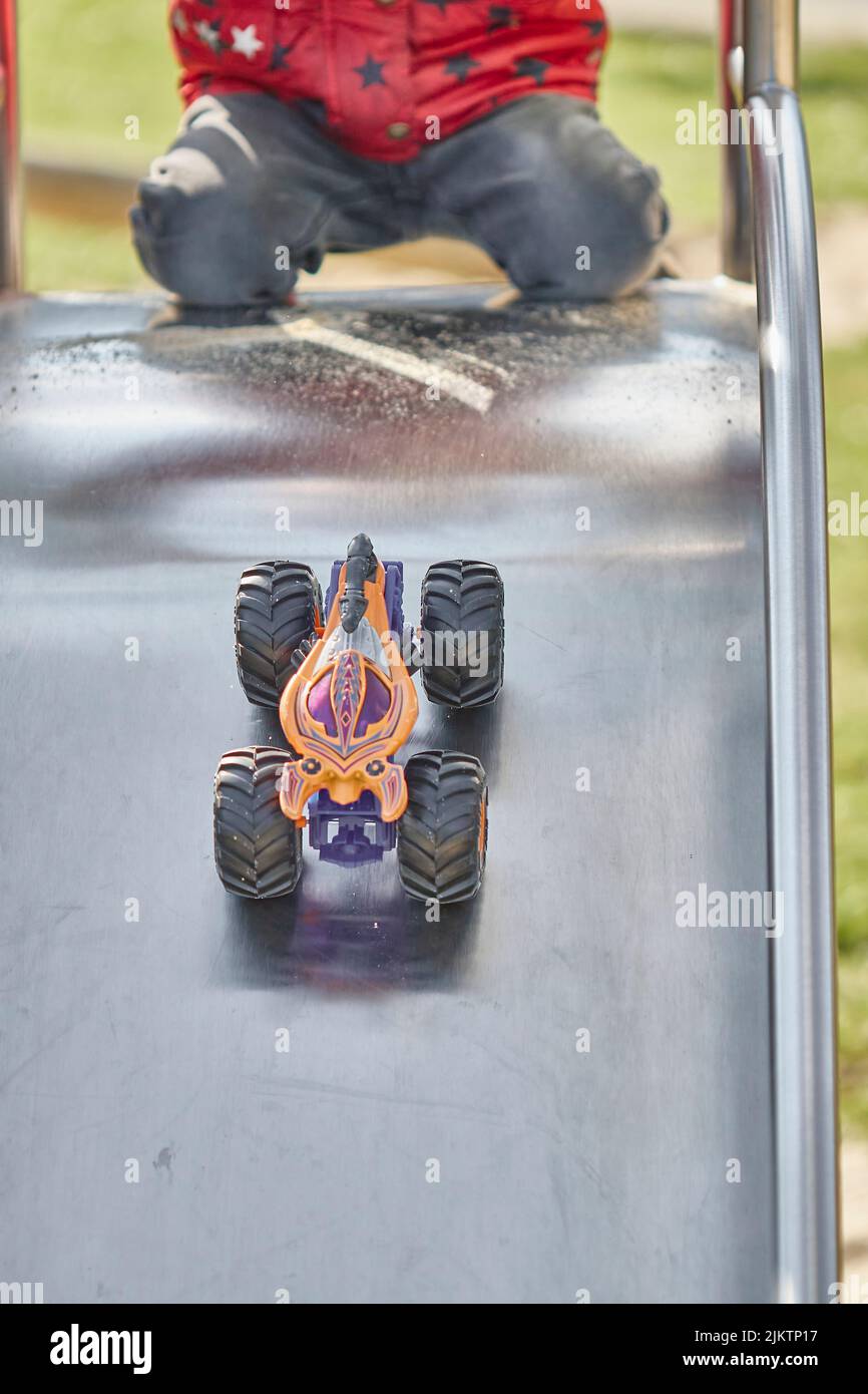 A child playing with a hot wheels monster truck in the playground Stock
