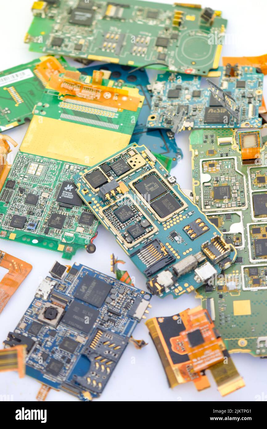 A vertical closeup of a mobile phone mainboard components containing gold Stock Photo