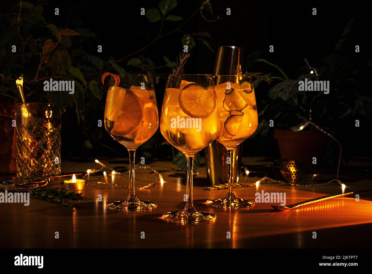 The three different gin tonic cocktails in wine glass, cozy soft backround with plants and bar equipment Stock Photo