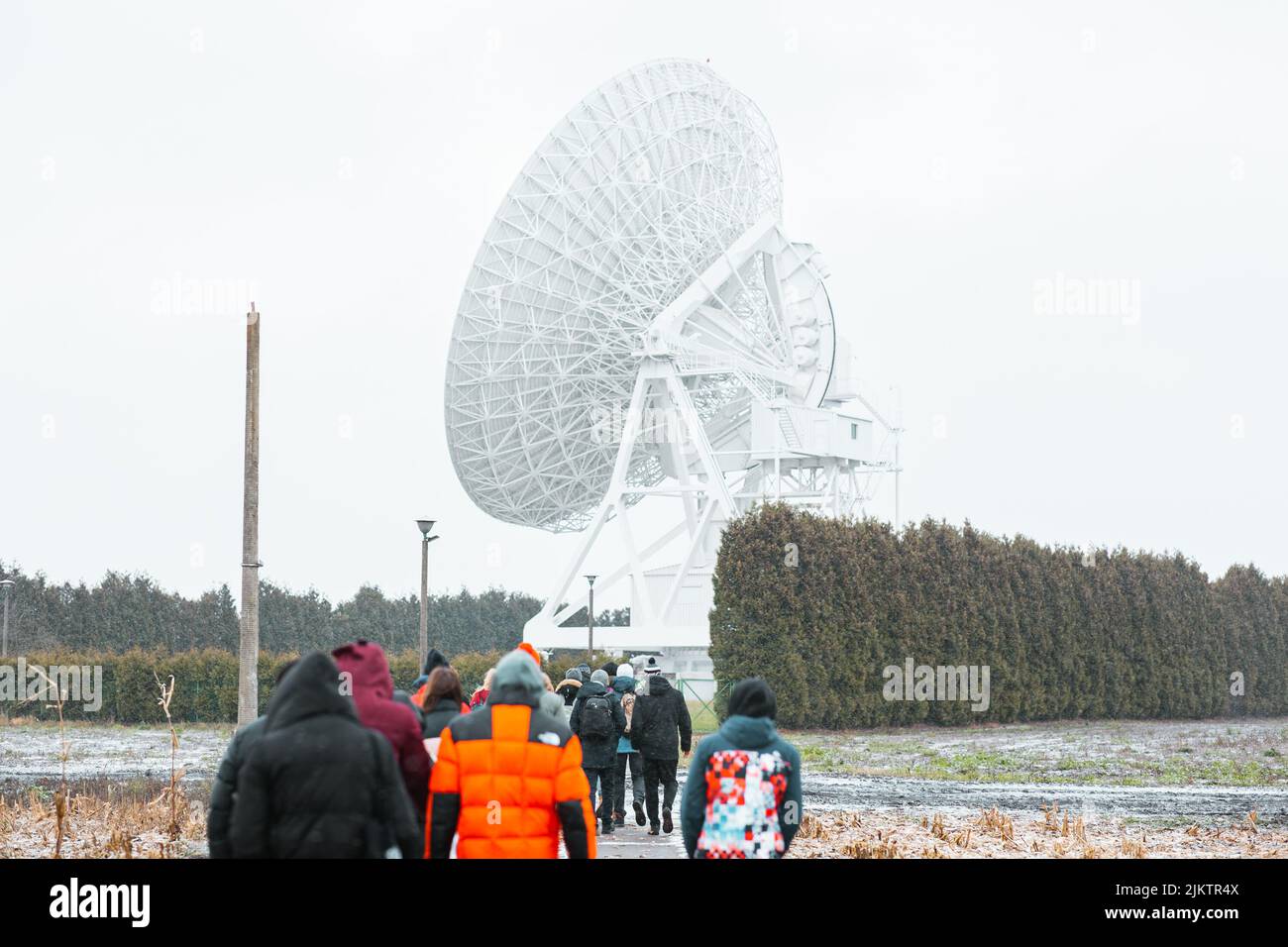 A group of people facing a large satellite antenna Stock Photo Alamy
