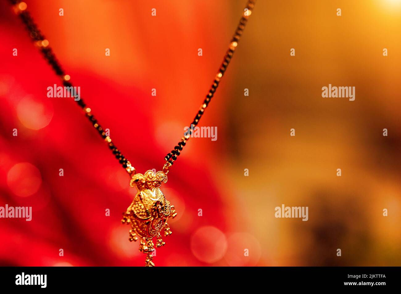A closeup shot of a black and golden Indian marriage necklace (mangala sutra) with a blurred background Stock Photo