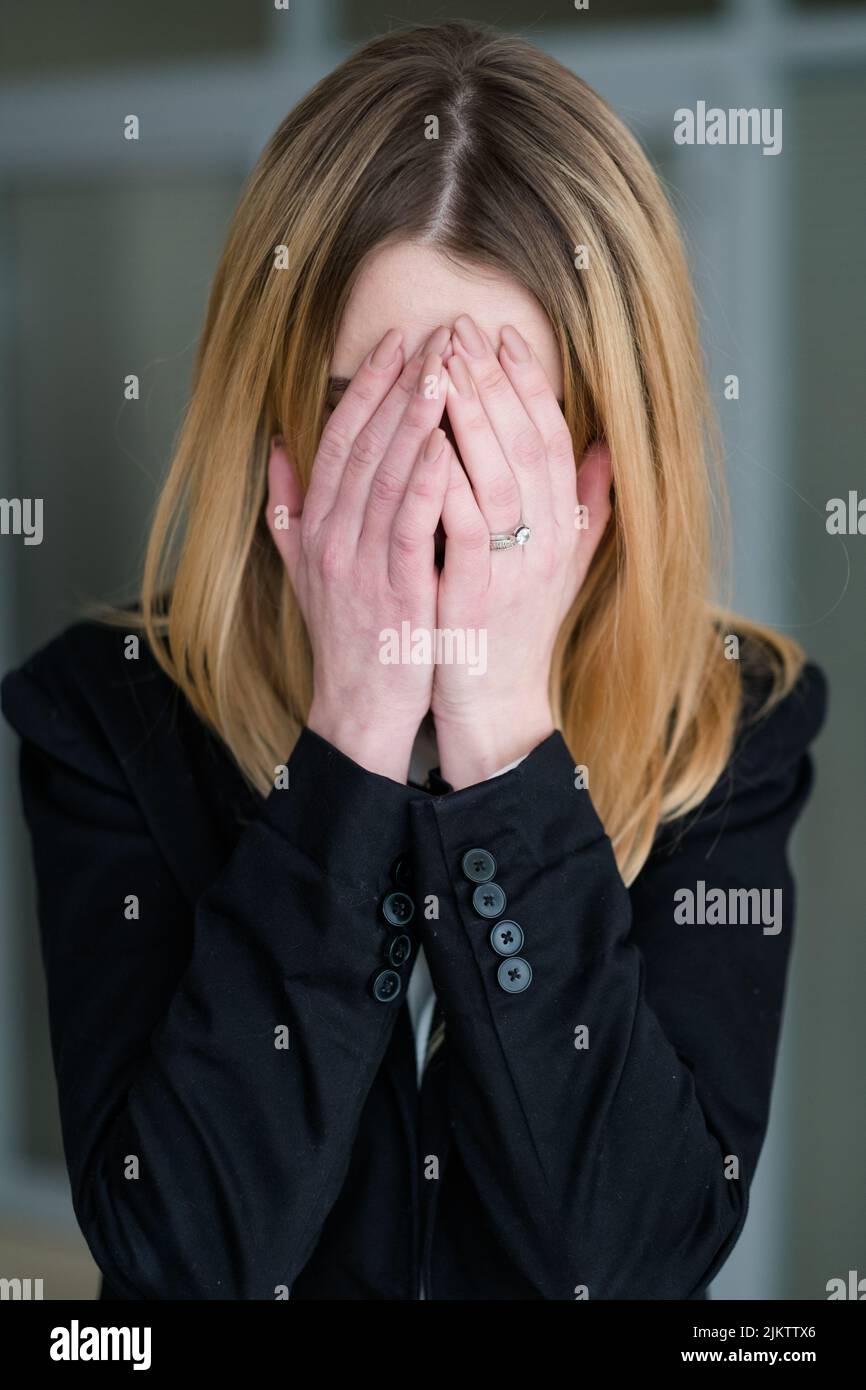 emotion sad distraught woman covering hands crying Stock Photo