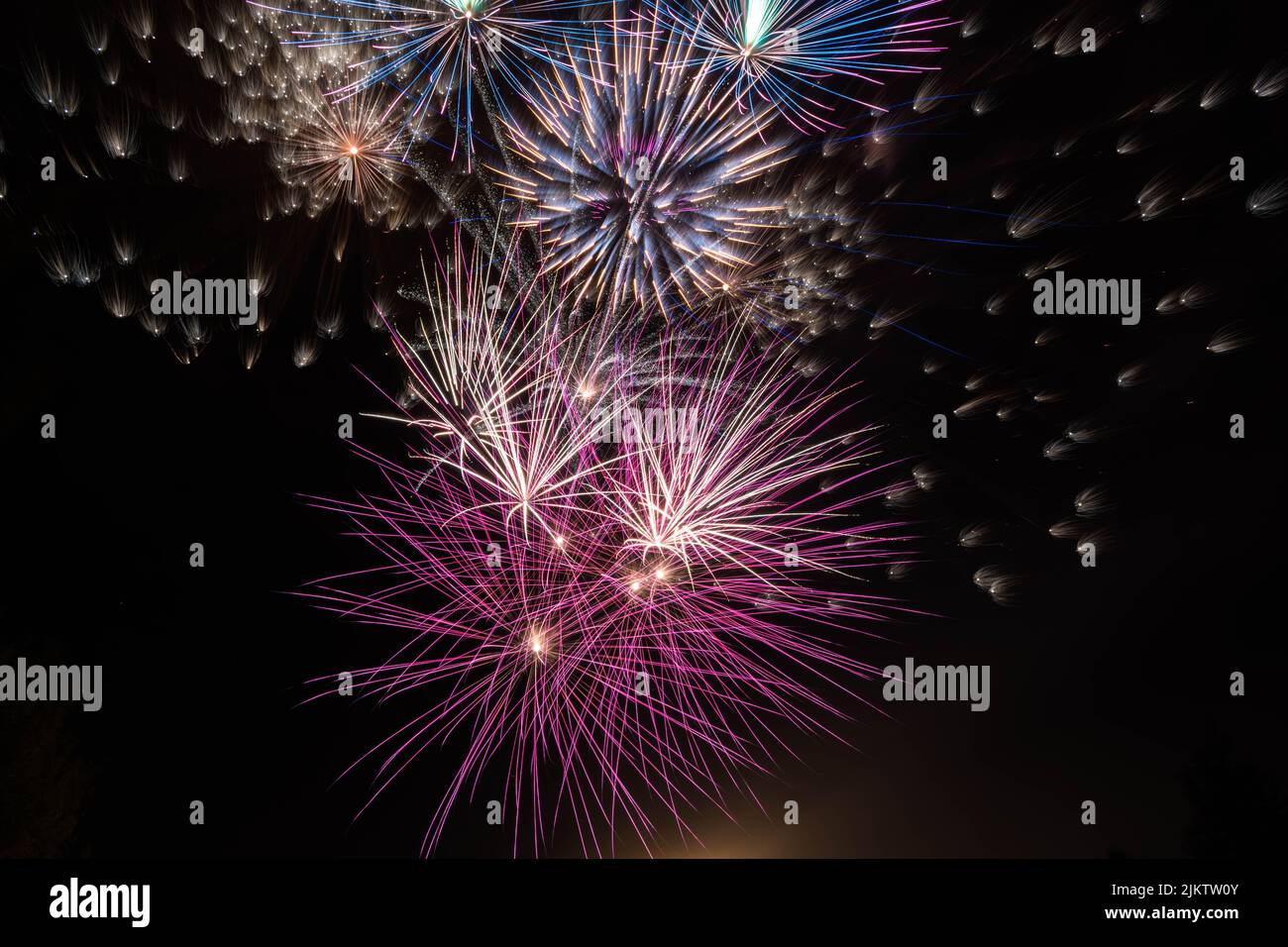 Colorful bright fireworks splashing in the dark black sky in Russia Stock Photo
