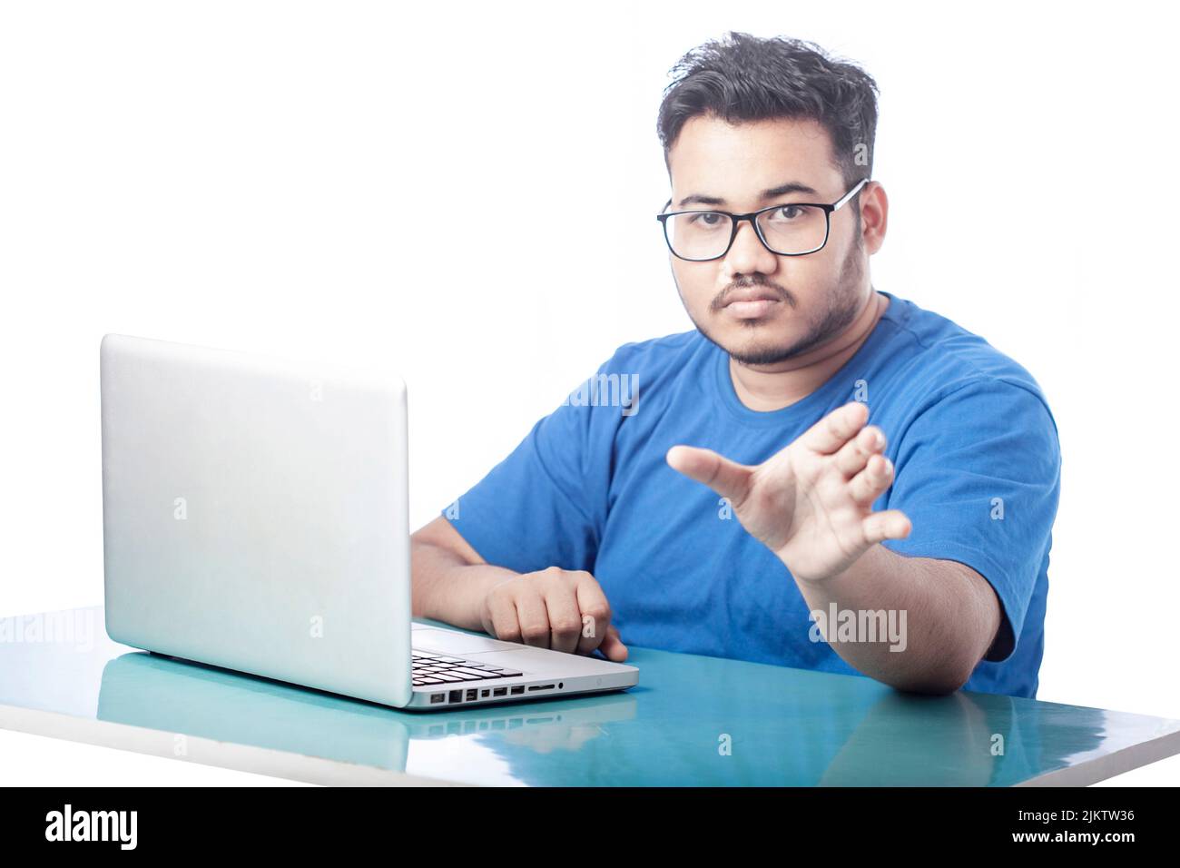 man using laptop and showing empty hand towards front Stock Photo