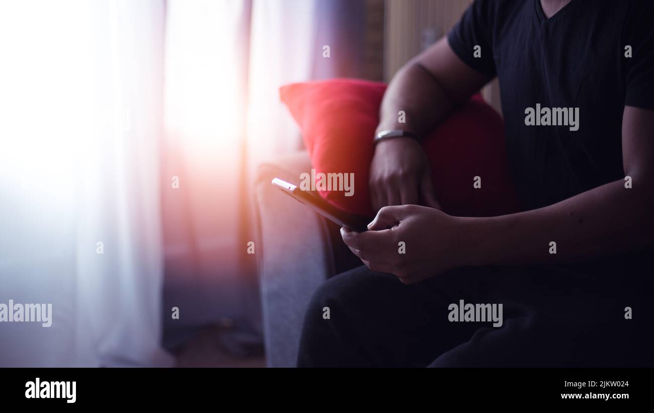 handsome man at home using his cell phone Stock Photo