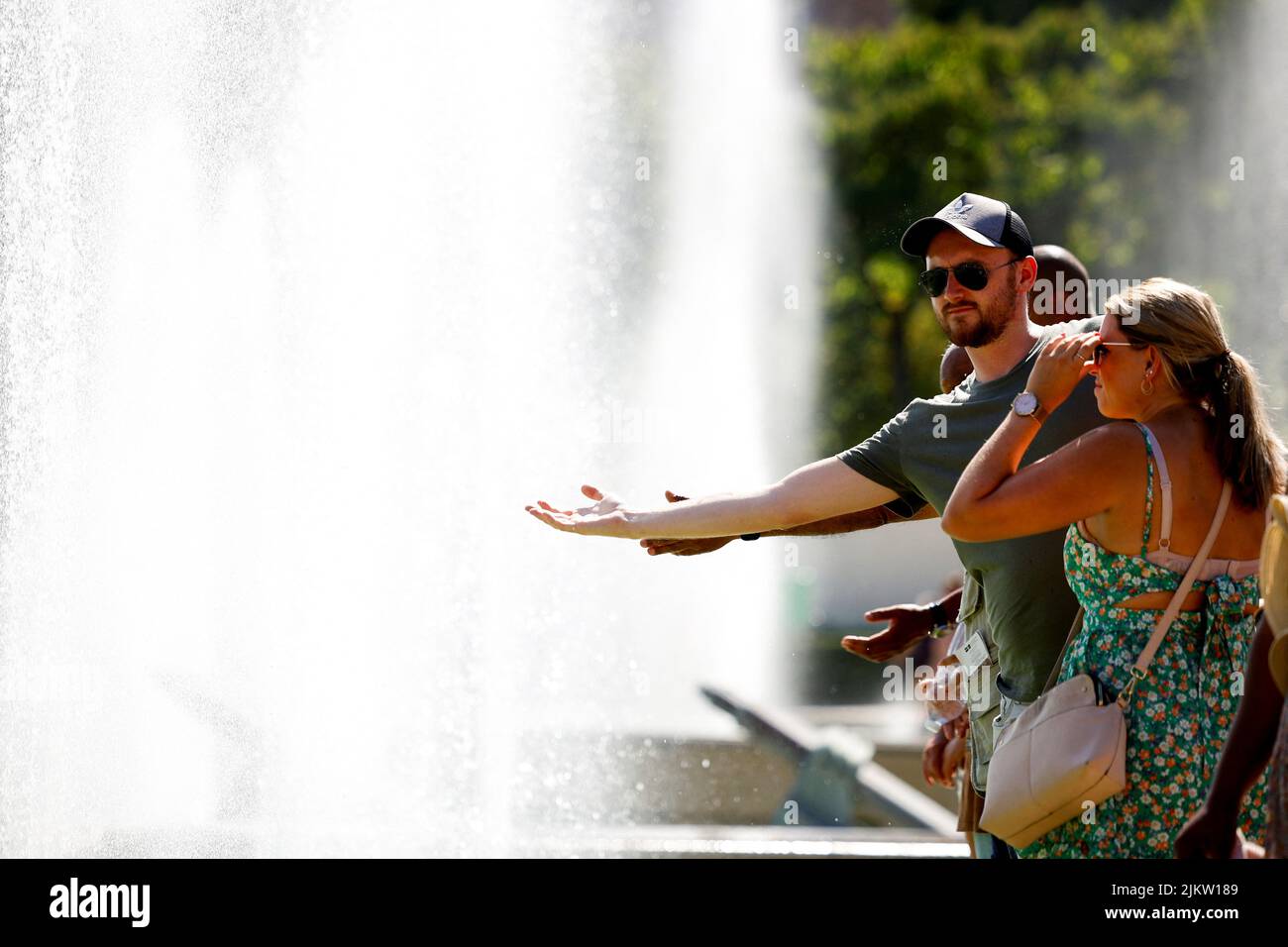 People cool off in the Trocadero fountains near the Eiffel Tower in Paris as a heat wave hits France, August 3, 2022. REUTERS/Sarah Meyssonnier Stock Photo