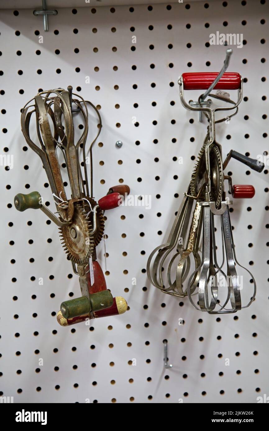 Antique, vintage egg beater on display on a peg board. Stock Photo