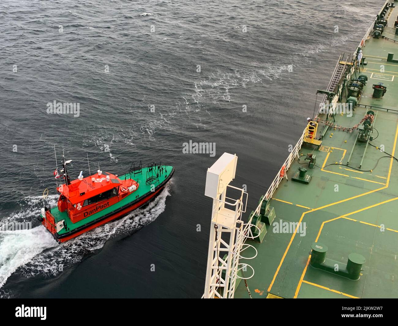 A pilot boat approaching to a big vessel in the sea Stock Photo Alamy