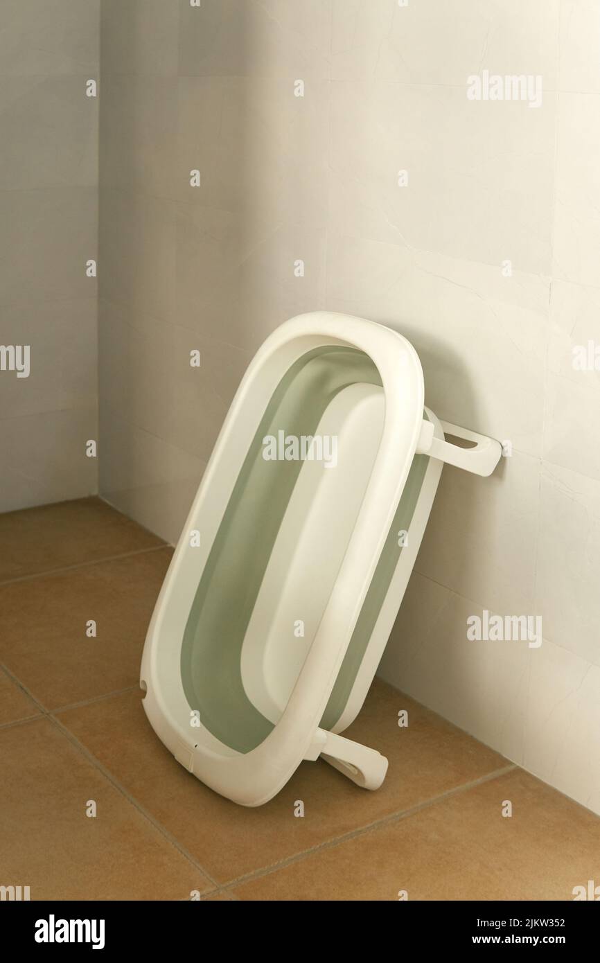 A vertical shot of a bath tub for small children leaned on the wall Stock Photo