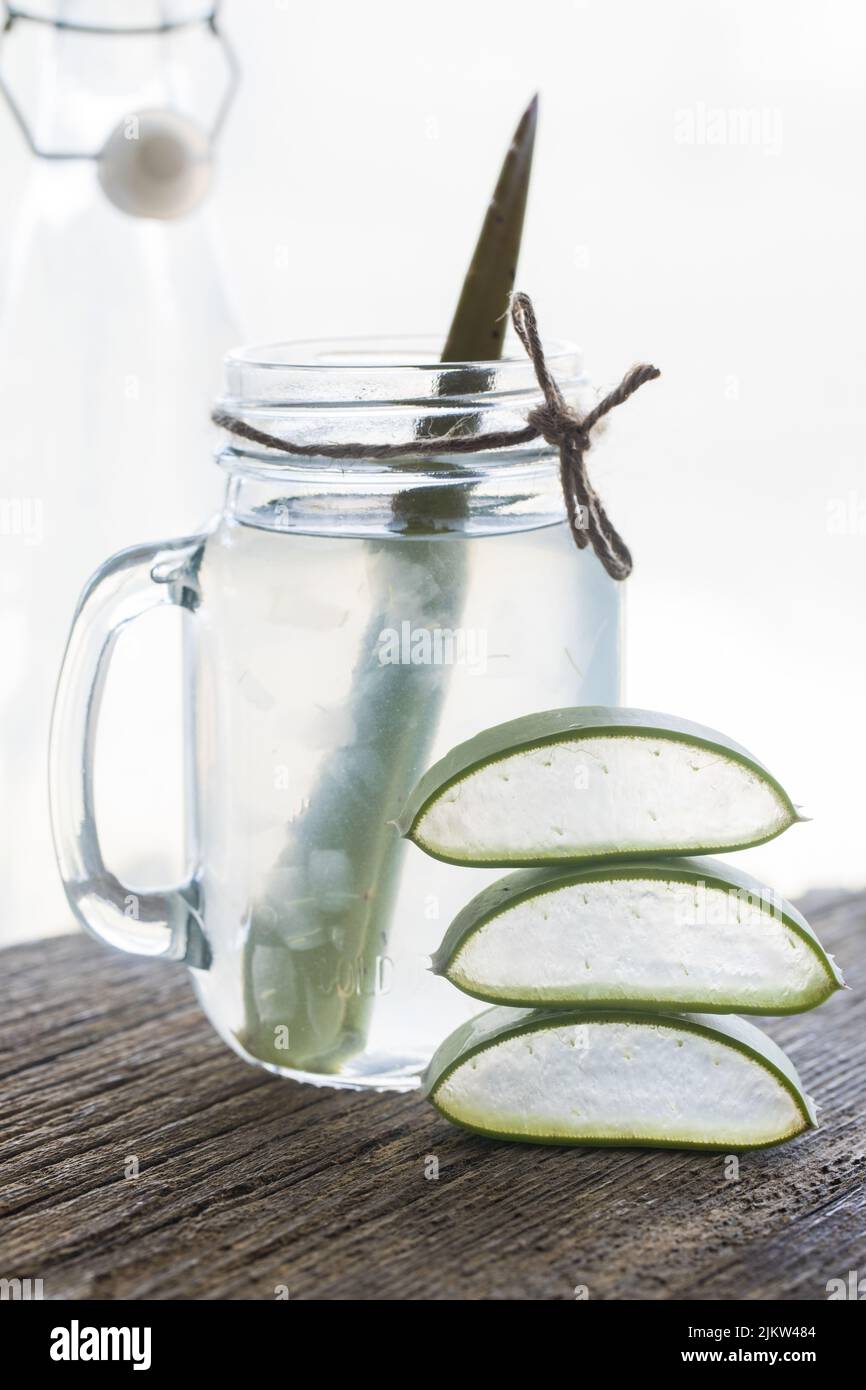 A glass of fresh pulp aloe vera juice with bright light coming in from ...