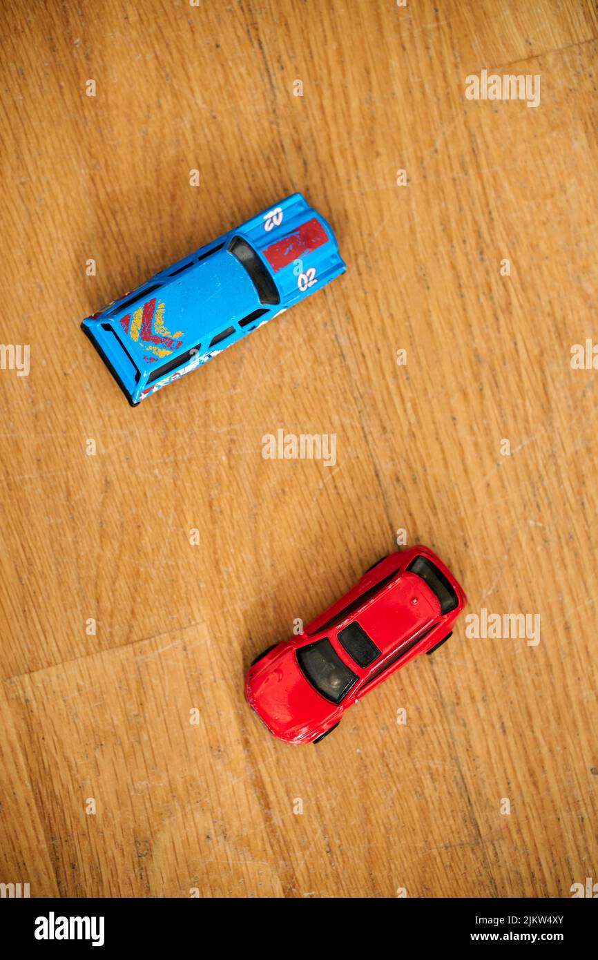 The blue and red Mattel Hot Wheels toy model cars on a wooden floor Stock Photo