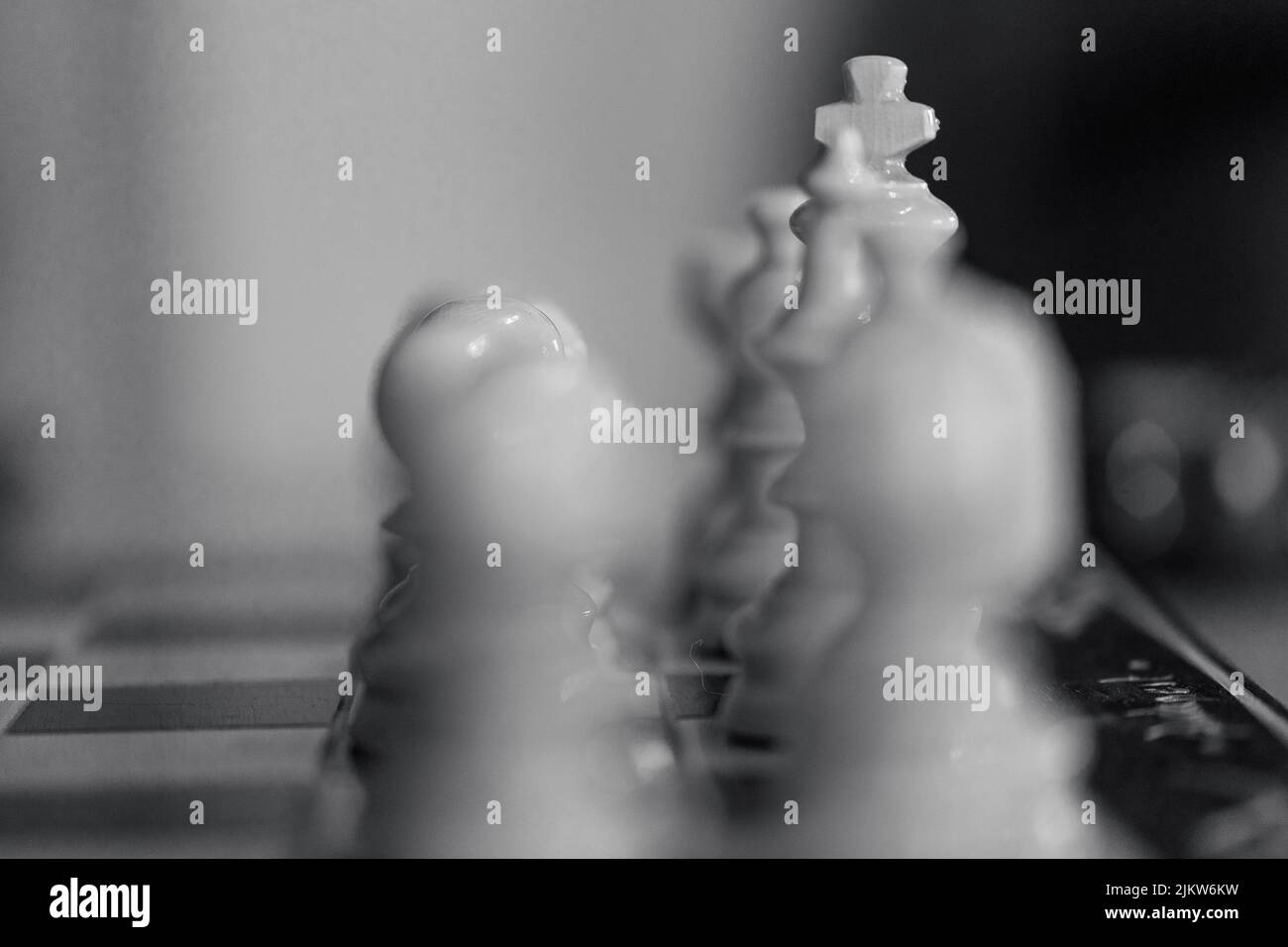 A grayscale closeup of the white chess pieces. Selected focus. Stock Photo