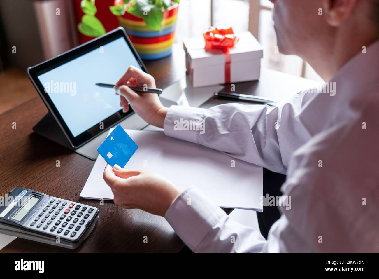Woman using digital tablet with credit card, ordering online shopping christmas gifts. Working from home concept Stock Photo